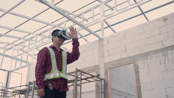 Asian architect engineer worker man in protective helmet and uniform using VR gear glasses