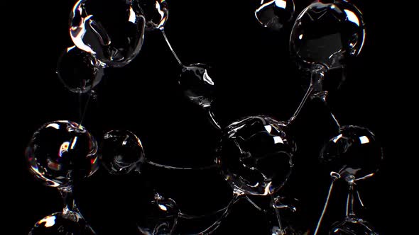 Spheres Of Water Are Separated From Transparent Threads On A Black Background alt