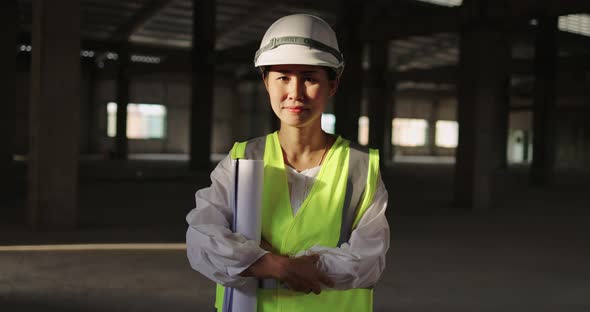 Asian Industrial Engineer Woman In Hard Hat Wearing Safety Jacket Working In Construction Site.