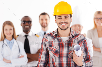 ung man in hardhat holding blueprint and smiling while group of people in different professions standing in the background