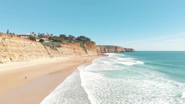 Porto De Mós sandy beach enclosed by Turquoise sea and golden Cliffs, Lagos, Algarve, Portugal