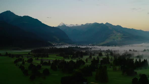 Drone Over Misty Landscape Of Zell Am See To Mountains At Dawn