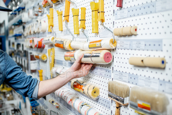 Man choosing tools for painting in the shop / Photodune, Misc