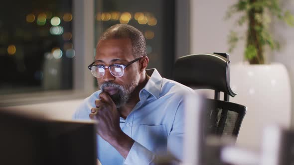 Professional businessman working while sitting on his desk in modern office in slow motion