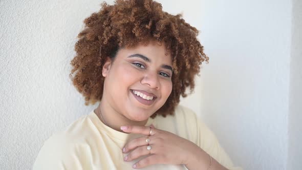 Beautiful Happy Smiling Curvy Plus Size African Black Woman Afro Hair with Make Up Posing in Beige