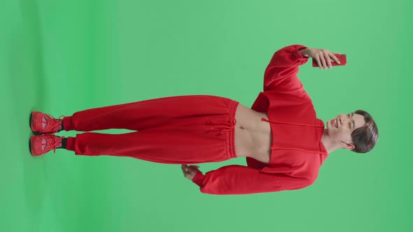 Full Body Of The Smiling Asian Transgender Male Having Video Call While Standing On Green Screen