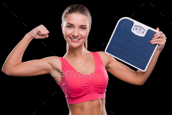  scale and showing her bicep while standing against black background