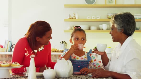 Happy multi-generation family having tea in dining table 4k