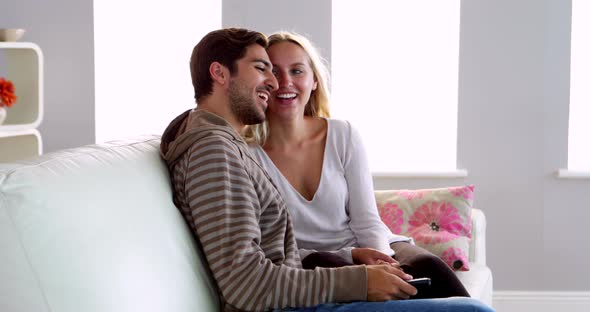 Happy Couple Sitting on the Couch Watching TV Together