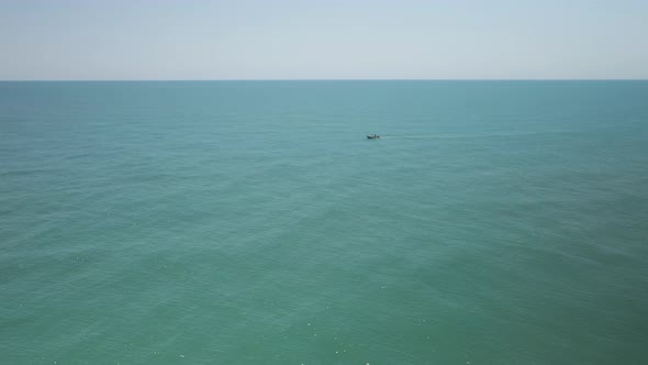 A single fishing boat among vast empty sea