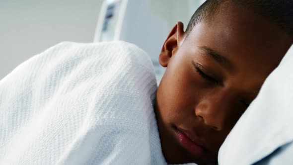 Sick boy sleeping on the bed in the hospital