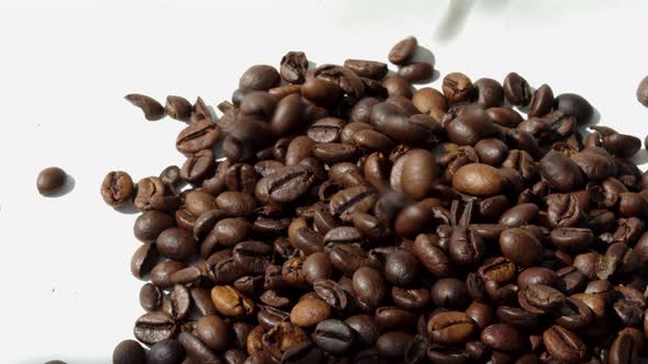 freshly roasted coffee beans falling from pack on table,flat surface,pouring from up down.sunny rays