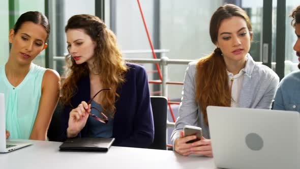 Business executives discussing over laptop in meeting