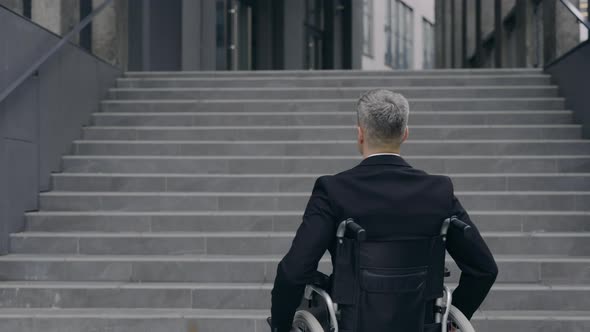 Backside View of Male Person in Suit on Wheelchair Standing at Street