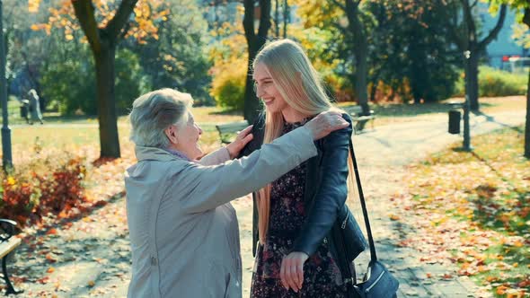 Grandmother and Granddaughter Hugging Each Other in Park