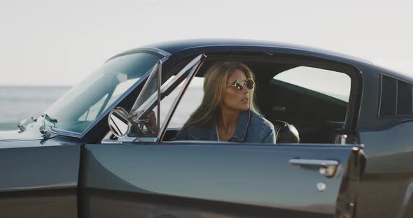 Beautiful woman sitting in a vintage sports car