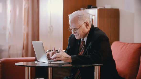 Elderly Grandfather - Grandfather Is Slowly Writing Something on the Computer in the Room