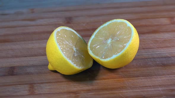 Slider Shot of Sliced Lemon Halves on a Wooden Chopping Board in the Kitchen