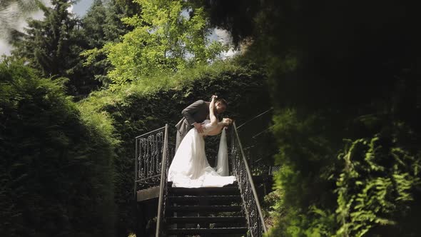 Newlyweds Caucasian Groom with Bride Stay on Stairs in Park Wedding Couple Man and Woman in Love