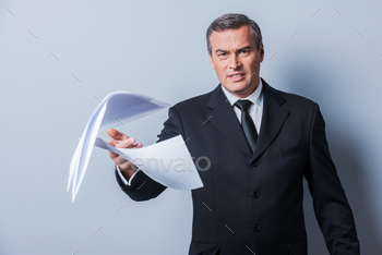 r throwing documents while standing against grey background
