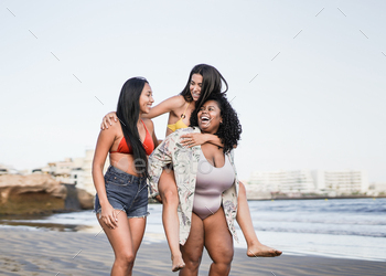Happy young latin women walking on the beach and enjoy summer vacation together / Photodune, Misc
