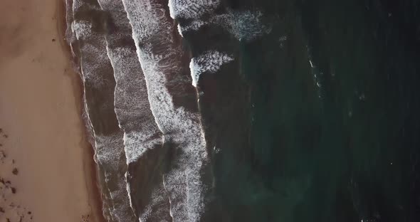 Drone flying over sea shore of Mediterranean Monsul beach while waves break. Almeria, Spain