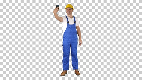 Smiling handsome young builder making selfie with mobile