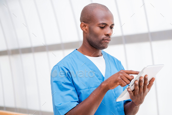 Surgeon with digital tablet. / Photodune, Misc