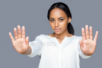 r palms while keeping her hands outstretched and standing against grey background