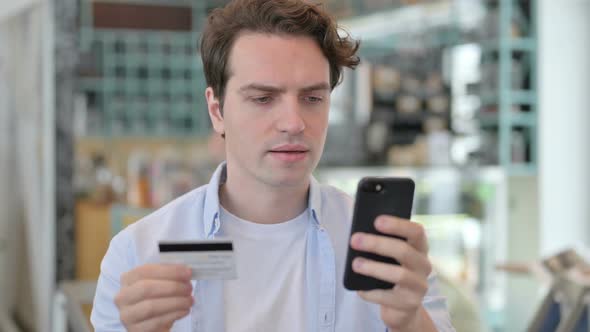 Portrait of Creative Man with Unsuccessful Online Payment on Smartphone