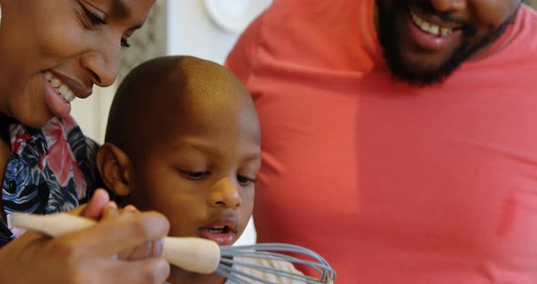 Parents and son preparing food in kitchen at home 4k