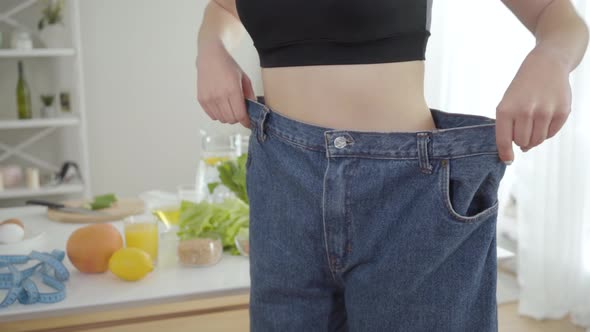 Unrecognizable Young Slim Woman in Big Jeans