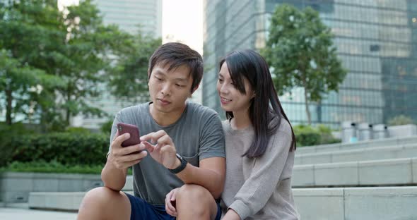 Couple use of mobile phone in city