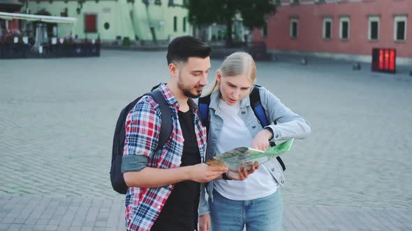 Two Tourists Holding Map and Looking for Some Place on City Square