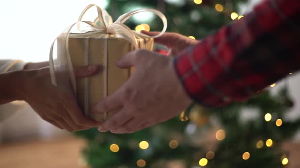 Hands Giving and Receiving Christmas Gift Box 