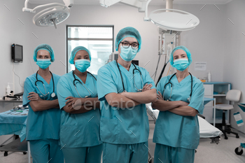 Diverse group of male and female doctors standing in operating theatre wearing face masks / Photodune, Misc