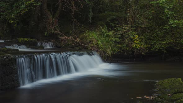 Time lapse of forest waterfall in rural landscape during autumn in Ireland. alt