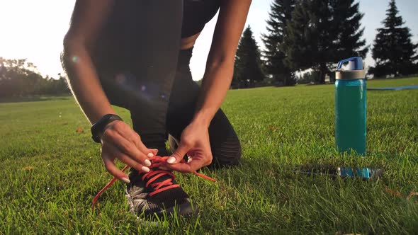 Fit Woman Athlete Tying Laces on Sneakers in Park
