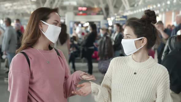 Two Women in Medical Mask Portrait Laughing and Emotionally Talking in Airport Terminal Preventing