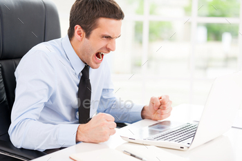 ooking at computer monitor and shouting while sitting at his working place