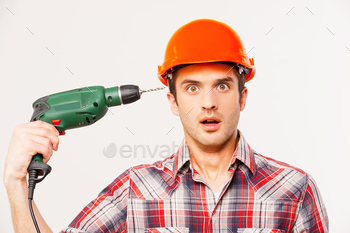  head with drill and looking at camera while standing against grey background