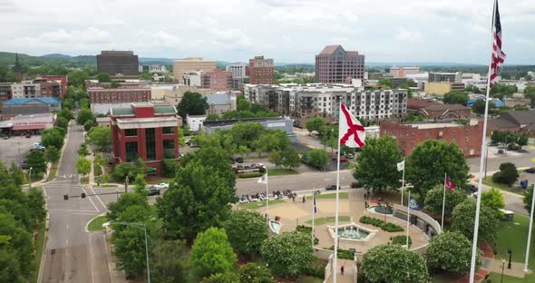 Huntsville, Alabama skyline with drone video moving up showing flags.