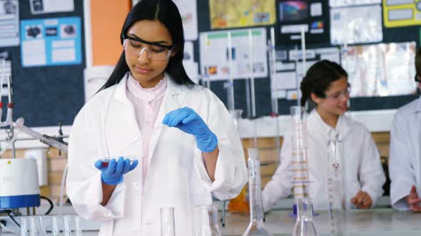 School girl experimenting with chemical in laboratory at school