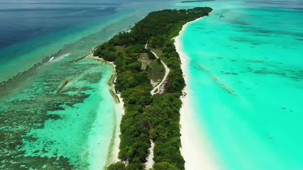 Daytime drone tourism shot of a sunshine white sandy paradise beach and blue water background in col