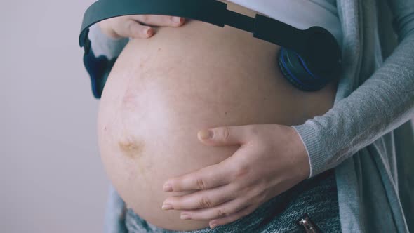 Pregnant Lady Listens To Music with Baby Dancing Closeup
