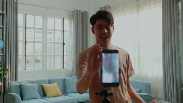 Asian Man Dancing While Shooting Video Content For Social Networks With A Smartphone Camera