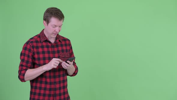 Young Handsome Hipster Man Using Phone While Waiting