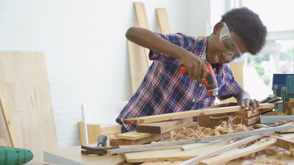 Little child wearing shirt with a drill in hands and help dad assembling furniture shelf 