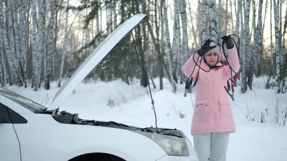 Woman with Booster Jumper Cables at Winter