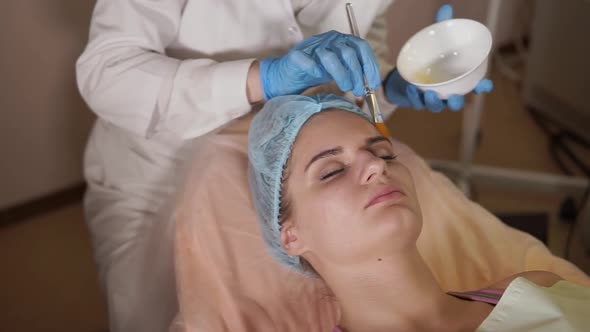 Cosmetologist Applying Facial Mask on Female Patient